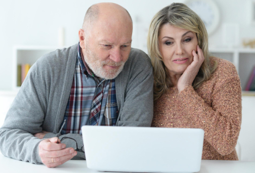 Middle-aged couple using laptop